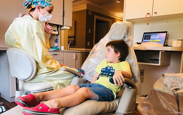 Young person talking to dentist during children's dentistry visit