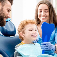 Dentist showing a child his smile in the mirror