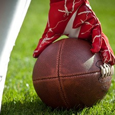 Close up of football player crouching with the ball