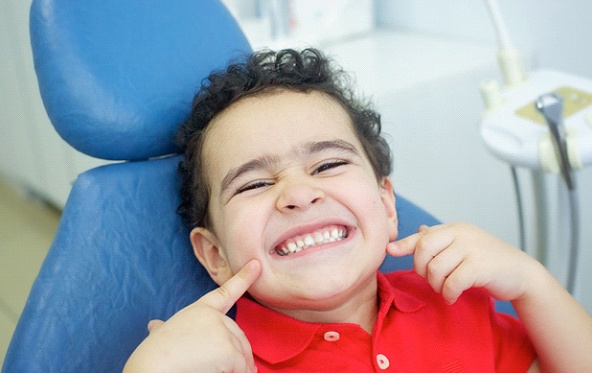 Grinning boy with straight teeth after using HealthyStart