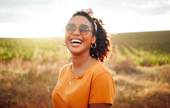 a person laughing and standing in a field