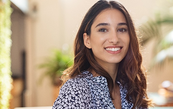 Close-up of smiling woman with flower-patterned shirt