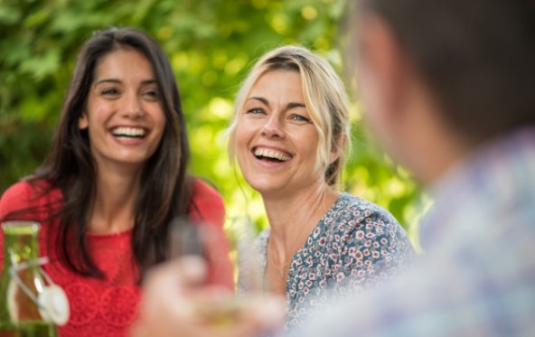 Two women smiling after dental implant tooth replacement