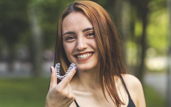 Woman placing Invisalign clear aligner tray