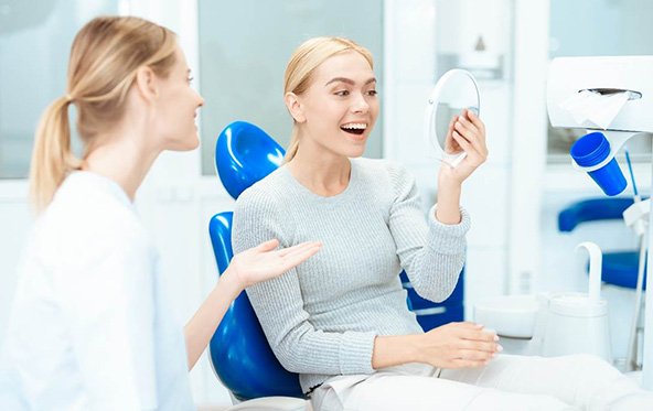 Woman looking at her smile in the mirror