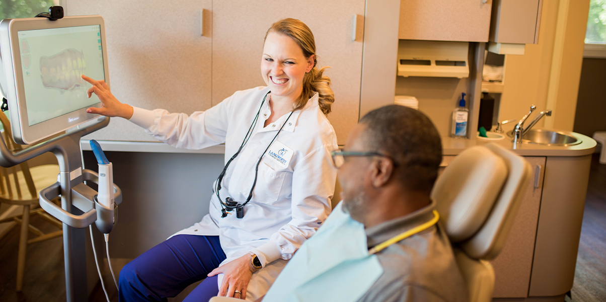 Dentist and patient looking at smile images on computer