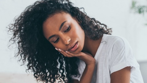 Woman in need of emergency dentistry holding jaw in pain