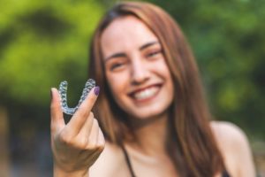 a woman smiling with her aligner