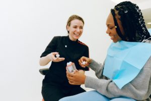 Dentist discussing dental crown with smiling woman